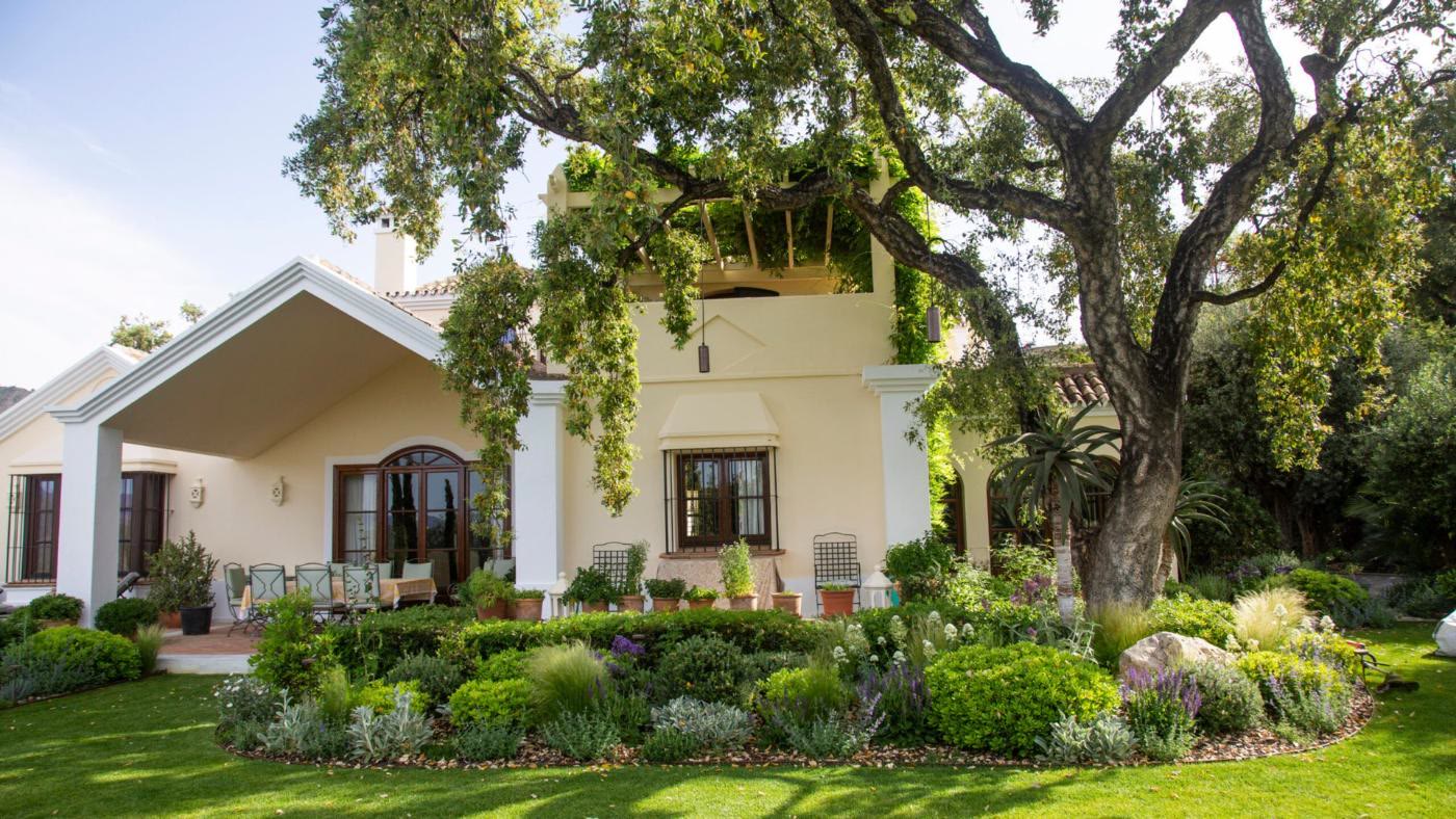 Villa con macizos de flores bajo encinas en La Zagaleta